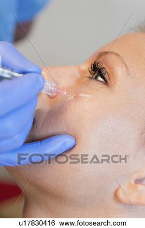 Woman having hyaluronic acid injections View Large Photo Image Stock Photograph - Woman having hyaluronic acid injections. Fotosearch