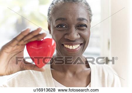 Stock Photo - Woman holding heart shape. Fotosearch