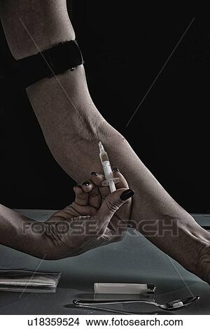 Picture - Woman injecting heroin. Fotosearch