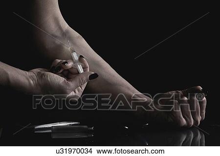 Picture - Woman injecting heroin. Fotosearch