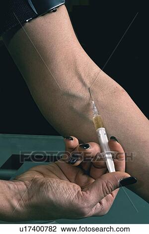 Stock Image - Woman injecting heroin. Fotosearch