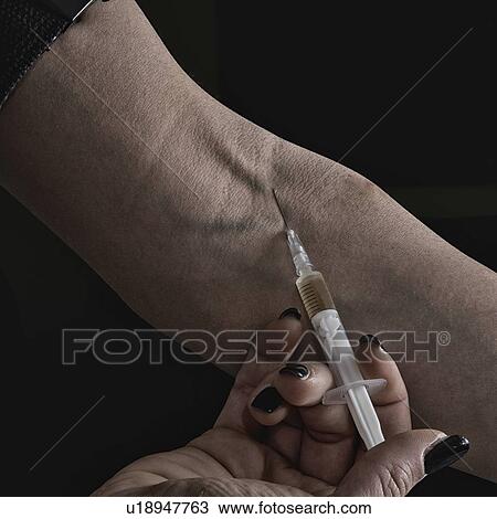 Stock Image - Woman injecting heroin. Fotosearch