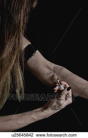 Stock Image - Woman injecting heroin. Fotosearch
