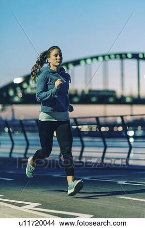 Woman jogging in city at night View Large Photo Image Picture - Woman jogging in city at night. Fotosearch