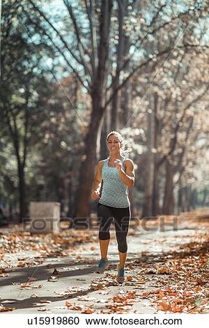 Stock Image - Woman jogging outdoors. Fotosearch