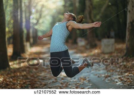 Woman jumping outdoors View Large Photo Image Stock Image - Woman jumping outdoors. Fotosearch
