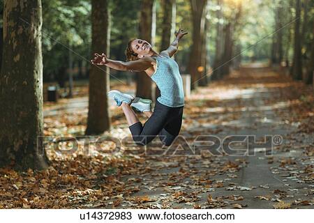 Stock Image - Woman jumping outdoors. Fotosearch