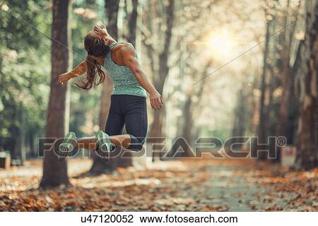 Woman jumping outdoors View Large Photo Image Stock Image - Woman jumping outdoors. Fotosearch