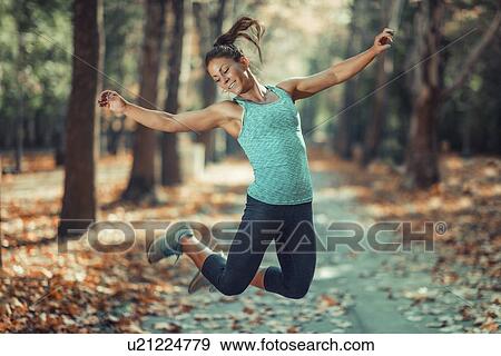 Stock Photo - Woman jumping outdoors. Fotosearch
