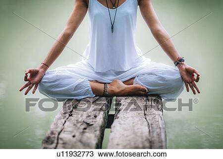 Woman meditating by a lake View Large Photo Image Stock Image - Woman meditating by a lake. Fotosearch