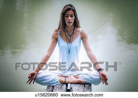 Woman meditating by a lake View Large Photo Image Stock Image - Woman meditating by a lake. Fotosearch
