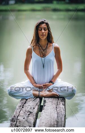 Woman meditating by a lake View Large Photo Image Stock Photo - Woman meditating by a lake. Fotosearch