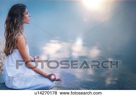 Woman meditating by a lake View Large Photo Image Stock Photo - Woman meditating by a lake. Fotosearch