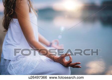 Woman meditating by a lake View Large Photo Image Stock Photograph - Woman meditating by a lake. Fotosearch