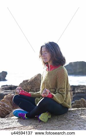 Woman meditating next to the sea View Large Photo Image Stock Photo - Woman meditating next to the sea. Fotosearch