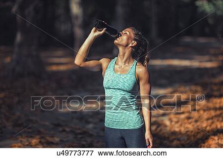 Woman resting and drinking water View Large Photo Image Stock Photo - Woman resting and drinking water. Fotosearch