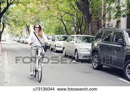 Woman riding electric bicycle View Large Photo Image Picture - Woman riding electric bicycle. Fotosearch
