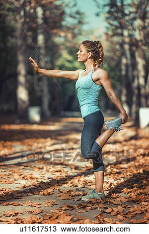 Stock Image - Woman stretching in the park. Fotosearch