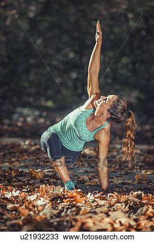 Stock Image - Woman stretching in the park. Fotosearch