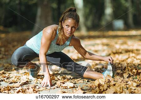 Woman stretching in the park View Large Photo Image Stock Photo - Woman stretching in the park. Fotosearch