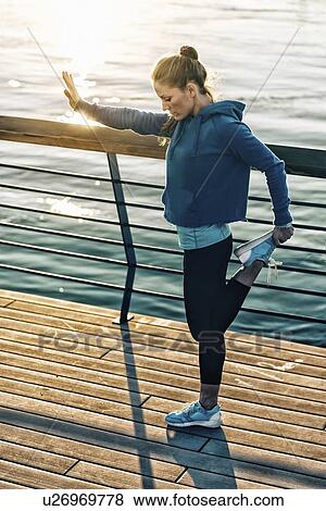 Stock Photo - Woman stretching on bridge. Fotosearch