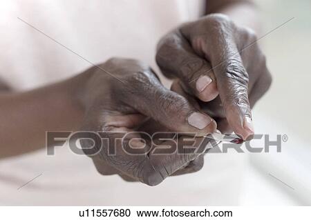 Stock Image - Woman testing blood glucose. Fotosearch
