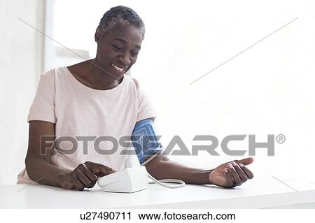 Woman testing blood pressure View Large Photo Image Stock Image - Woman testing blood pressure. Fotosearch