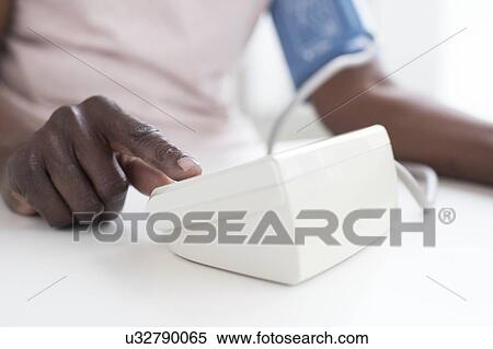 Stock Photography - Woman testing blood pressure. Fotosearch
