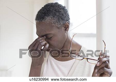 Woman touching bridge of nose View Large Photo Image Picture - Woman touching bridge of nose. Fotosearch