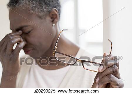 Woman touching bridge of nose View Large Photo Image Stock Photography - Woman touching bridge of nose. Fotosearch