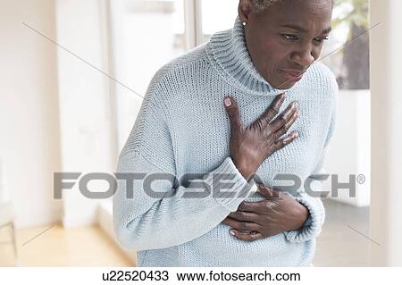 Woman touching chest in pain View Large Photo Image Stock Image - Woman touching chest in pain. Fotosearch