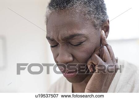 Woman touching ear View Large Photo Image Stock Photo - Woman touching ear. Fotosearch