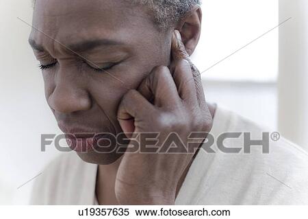 Stock Photography - Woman touching ear. Fotosearch