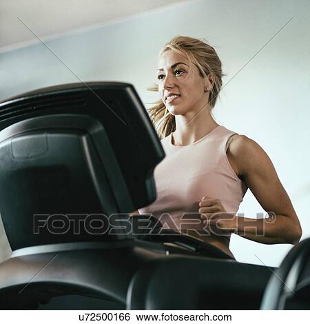 Stock Photograph - Woman using a treadmill. Fotosearch