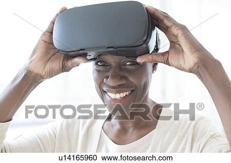 Stock Image - Woman wearing VR headset. Fotosearch