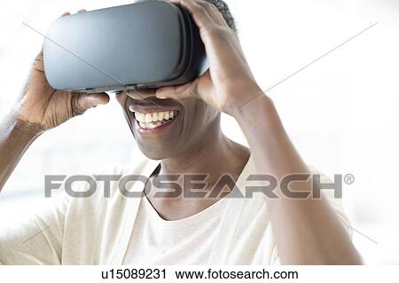 Stock Image - Woman wearing VR headset. Fotosearch