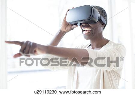 Woman wearing VR headset View Large Photo Image Stock Image - Woman wearing VR headset. Fotosearch