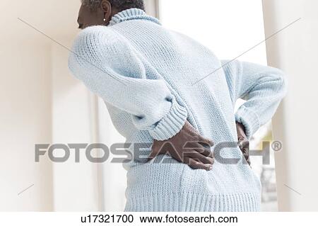 Stock Image - Woman with back pain. Fotosearch