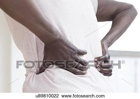Stock Image - Woman with back pain. Fotosearch