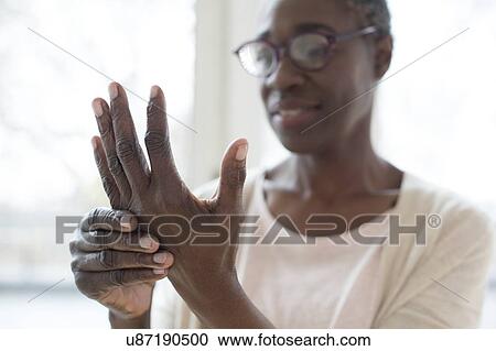 Stock Image - Woman with hand pain. Fotosearch