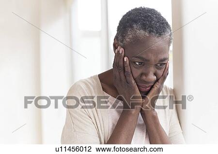 Stock Image - Woman with head in hands. Fotosearch