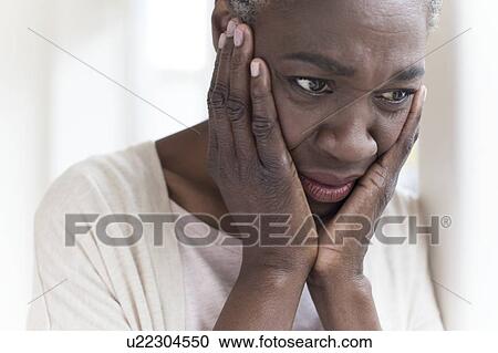 Stock Image - Woman with head in hands. Fotosearch