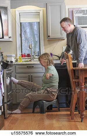 Stock Photograph - Woman with TAR Syndrome in kitchen. Fotosearch