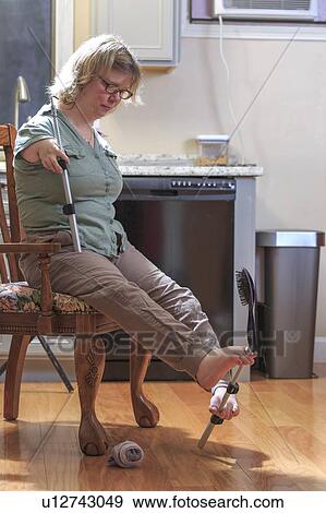 Woman with TAR Syndrome picking up hair brush with her feet View Large Photo Image Stock Photo - Woman with TAR Syndrome picking up hair brush with her feet. Fotosearch