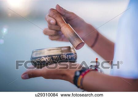 Picture - Woman with Tibetan singing bowl. Fotosearch