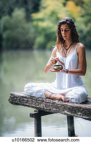 Stock Image - Woman with Tibetan singing bowl. Fotosearch