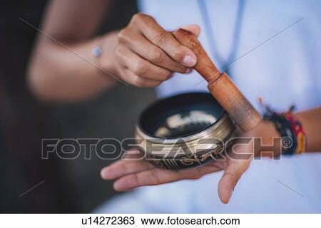 Stock Image - Woman with Tibetan singing bowl. Fotosearch