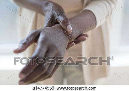 Stock Image - Woman with wrist pain. Fotosearch