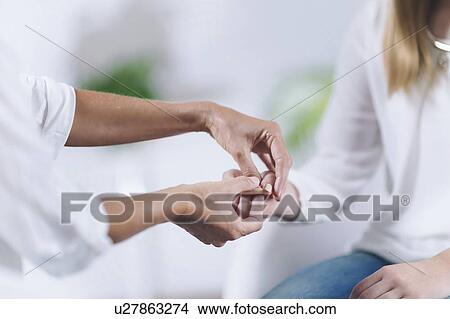 Picture - Women holding hands at theta healing session. Fotosearch