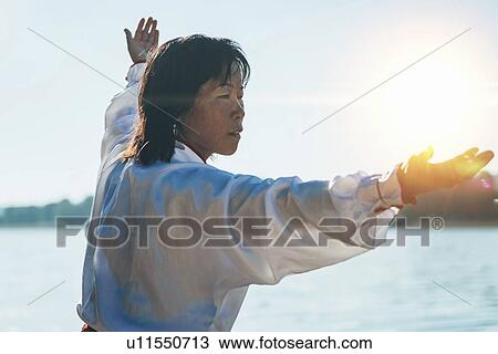 Women practicing tai chi by lake View Large Photo Image Stock Image - Women practicing tai chi by lake. Fotosearch